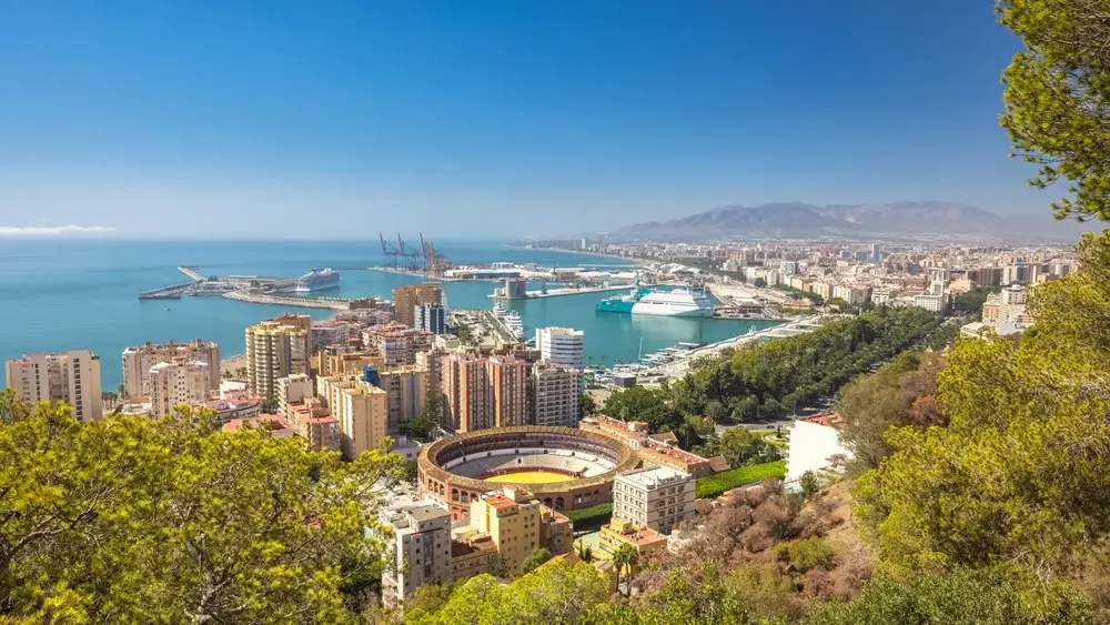 Udsigt over Málaga med by, havn og bjerge i baggrunden